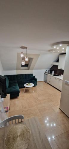 a living room with a green couch and a kitchen at ewja 3 in Sulęcin