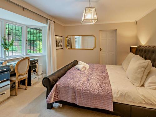 1 dormitorio con cama, escritorio y ventana en Riverside House en Cookham