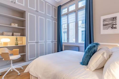 a bedroom with a bed and a desk and a window at Appartement de luxe in Paris