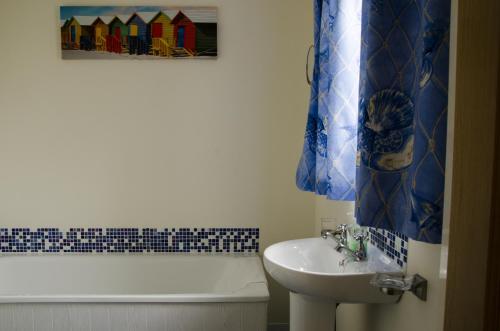 ein Badezimmer mit einem Waschbecken, einer Badewanne, einem WC und einem Waschbecken in der Unterkunft Ulster Cottages 4 miles From Portrush Bushmills Coleraine and Ballymoney in Bushmills