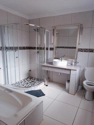 a bathroom with a tub and a sink and a toilet at Pecan Farm Guesthouse in Louis Trichardt