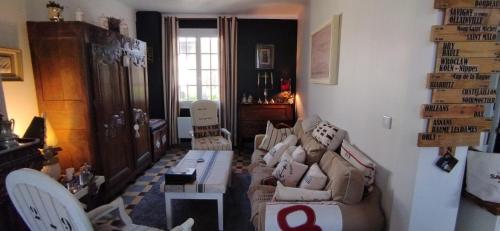 a living room with a couch and chairs in it at Une chambre en ville in Domfront