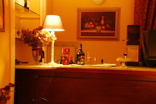 a table with a lamp and a bottle of wine at Hotel del Centro in Palermo