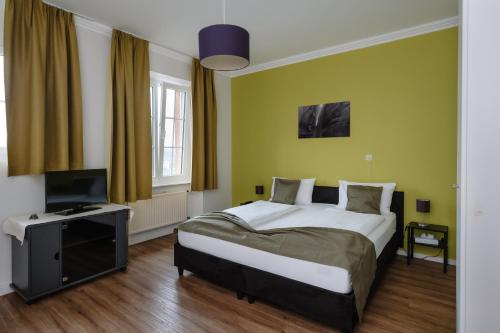 sypialnia z łóżkiem i telewizorem z płaskim ekranem w obiekcie Trail-Inn Natur & Sporthotel w mieście Berdorf