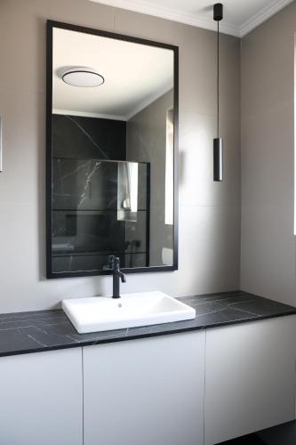 a bathroom with a white sink and a mirror at VILLA MARIS SMRIKA -heated pool in Šmrika