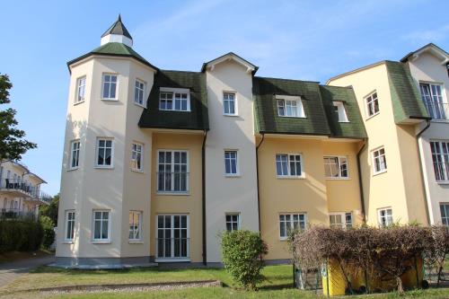 un gran edificio amarillo con techo verde en Feriendomizil Goethestraße, Wohnung Strandläufer Whg 15, en Ahlbeck