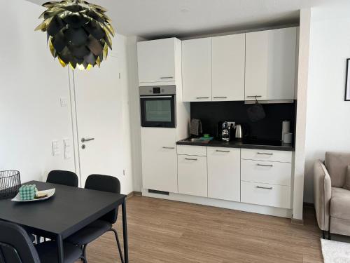 a kitchen with white cabinets and a dining room table at Rosengarten Apartments in Tettnang in Tettnang