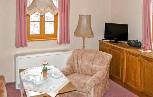 a living room with a chair and a table and a television at Ferienwohnung Neuhausen in Neuhausen