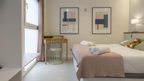 1 dormitorio con 2 camas y una mesa con toallas en Osito Hub - l'Explorador Andrés, en Valencia