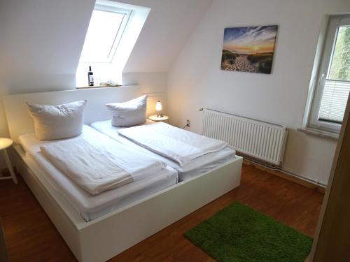 a bedroom with a bed with white sheets and pillows at Seeigel in Gruberhagen