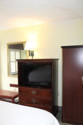 ein Schlafzimmer mit einem Bett und einem Flachbildfernseher in der Unterkunft Days Inn by Wyndham Marianna in Marianna