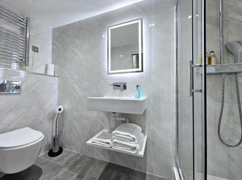 a bathroom with a toilet and a sink and a shower at NOX Hyde Park in London