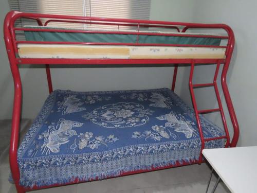 Una litera roja con una alfombra azul. en Casa Exploradores, en Volcán