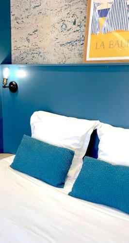 een bed met twee blauwe kussens erop bij Refuge au Cœur de La Baule in La Baule