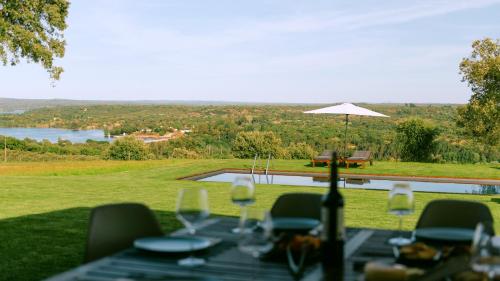 - une table avec des verres à vin et une vue dans l'établissement MONTE DA FIFAS Alentejo, Montargil, à Montargil