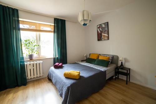 Dormitorio con cama con almohada amarilla en Apartment Rajzefiber - Spodek - MCK - NOSPR, en Katowice