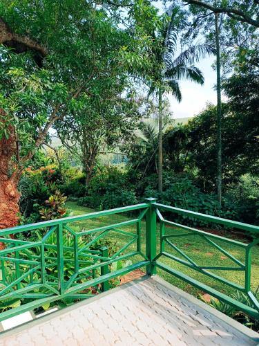 a green railing on a walkway in a garden at Pecan Farm Guesthouse in Louis Trichardt