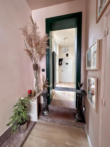 a hallway with a door and a vase with flowers at Maison Georges in Tourcoing