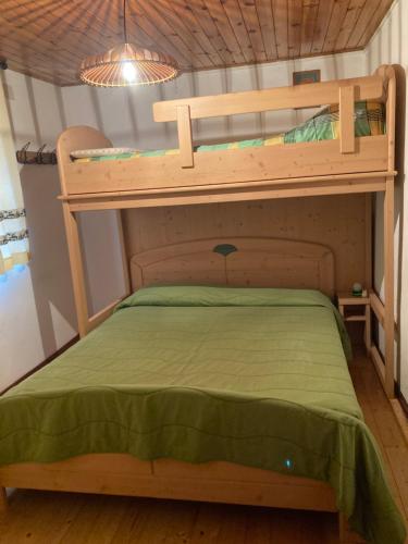 two bunk beds in a room with a green bedspread at Casa Laura in Ravascletto