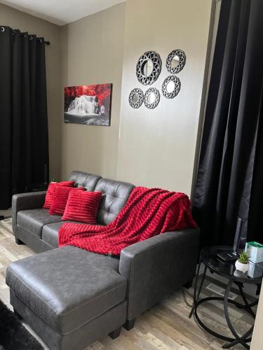 a living room with a couch and a red blanket at Old North Shanty in Saint Louis