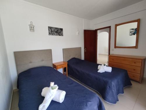 two beds with towels on them in a bedroom at 4D Torre Rafael - Casas & Papéis in Armação de Pêra