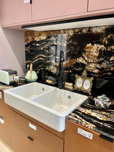 a kitchen counter with a sink and a wall at Maison Georges in Tourcoing