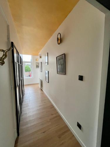 a hallway of a home with white walls and wooden floors at Maison Georges in Tourcoing