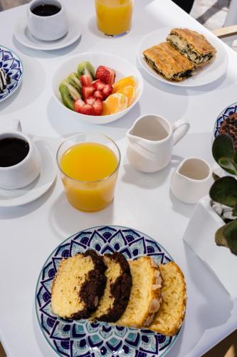 a table topped with plates of food and fruit at Nevma Suites in Firostefani