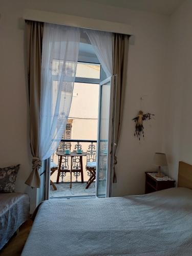 a bedroom with a bed and a door to a balcony at APARTMAN Riva 1 in Komiža