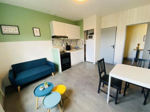 un salon avec un canapé bleu et une table dans l'établissement L oustal, à Rodez