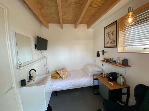 a small room with a bed and a sink at B&B Hoogeveen Centraal in Hoogeveen