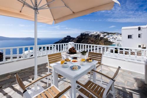 a white table with food on top of a balcony at Nevma Suites in Firostefani