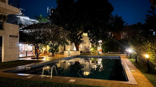 a swimming pool in front of a building at night at VILLA M - SOLITUDE 2 CANDOLIM GOA 3BHK, Pool Facing, Near Beach, Free Breakfast, Free WIFI and Prime Location in Candolim