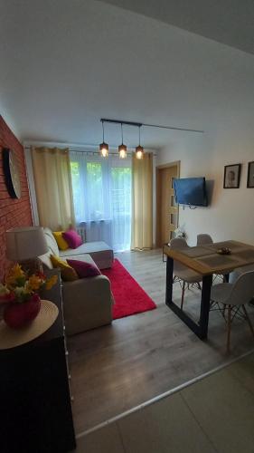 een woonkamer met een bank en een tafel bij MK Apartament II in Rzeszów