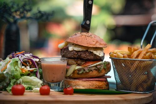 a hamburger and fries and a salad and a drink at Relais des Plateaux & Spa– Ivato International Airport in Antananarivo