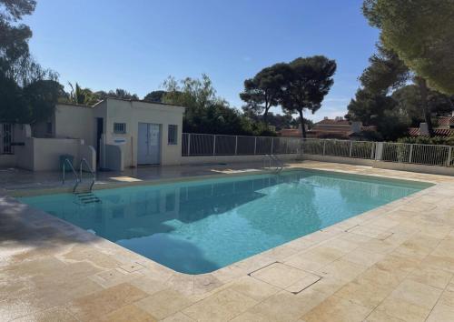 une piscine avec de l'eau bleue dans une cour dans l'établissement ACAPULCO 86&87, aux Issambres