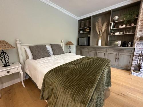 Camellia Cottage - Bay Room في كيب تاون: غرفة نوم بها سرير وتلفزيون