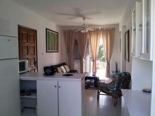 a kitchen with a white counter and a living room at Arithea 101 in Paphos