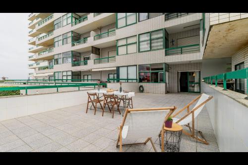a patio with chairs and a table in front of a building at Três Marias by LovelyStay in Aver-o-Mar