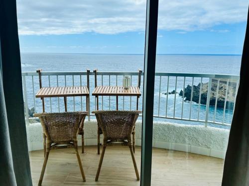 伊科德德洛斯維諾斯的住宿－Apartment Blue Monis with Amazing Views，俯瞰大海的阳台配有桌椅