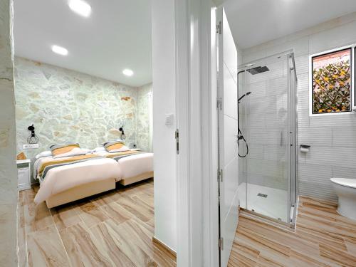 una camera con due letti e una cabina doccia di El Hortal i lloo a El Cuervo