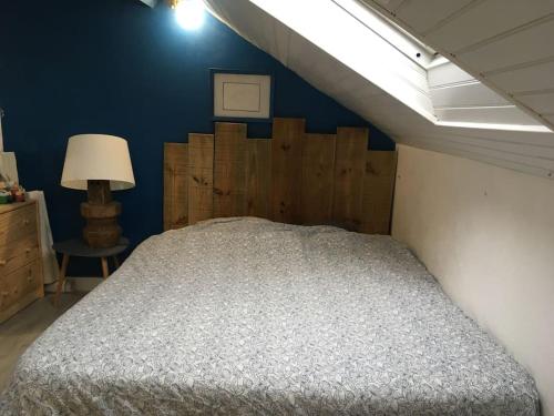 a bedroom with a bed and a blue wall at Appartement chez Loulou in Léon