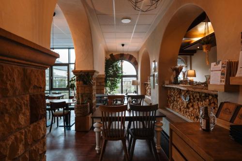 a restaurant with a dining room with tables and chairs at Trail-Inn Natur & Sporthotel in Berdorf