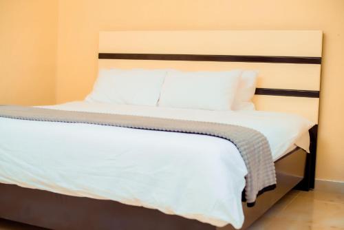 sypialnia z łóżkiem z białą pościelą i poduszkami w obiekcie Hillside Luxury Lodge w mieście Blantyre