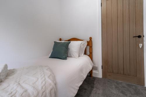 a bedroom with a bed with white sheets and pillows at Railway Retreat in Wakefield
