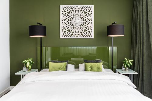 a bedroom with a large white bed with two lamps at Pension Montmaertre in Zierikzee