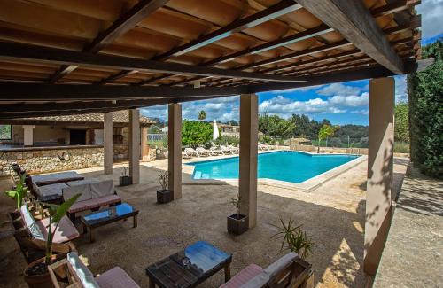 un patio con piscina y pérgola de madera en Agroturismo Ses Illes, en Costitx