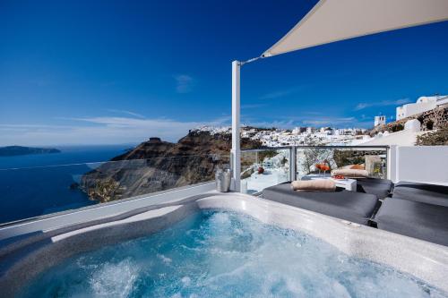 a hot tub with a view of the ocean at Nevma Suites in Firostefani