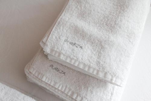 a white towel on a wall with the word linen on it at MonKeys Apartments Pureza House in Seville
