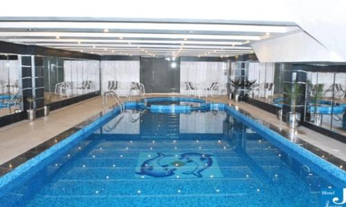 - une grande piscine d'eau bleue dans un bâtiment dans l'établissement Hotel Javson, à Sialkot